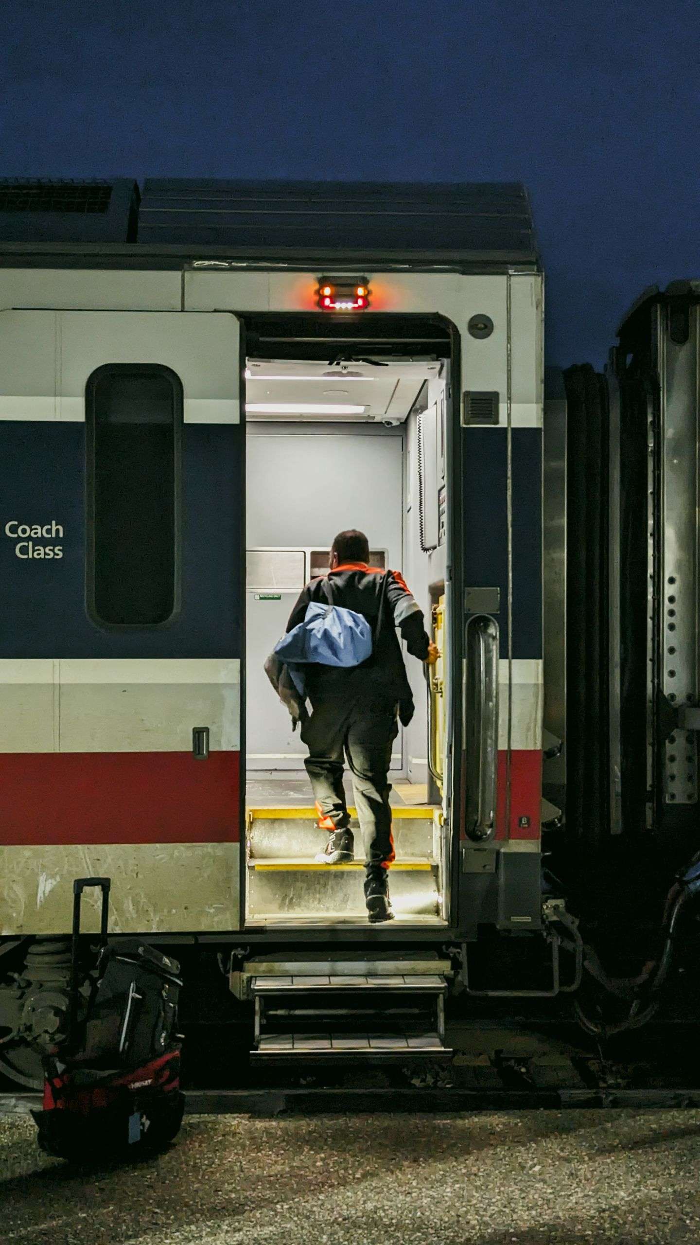 A man boarding a train at night, signaling a journey or travel adventure.