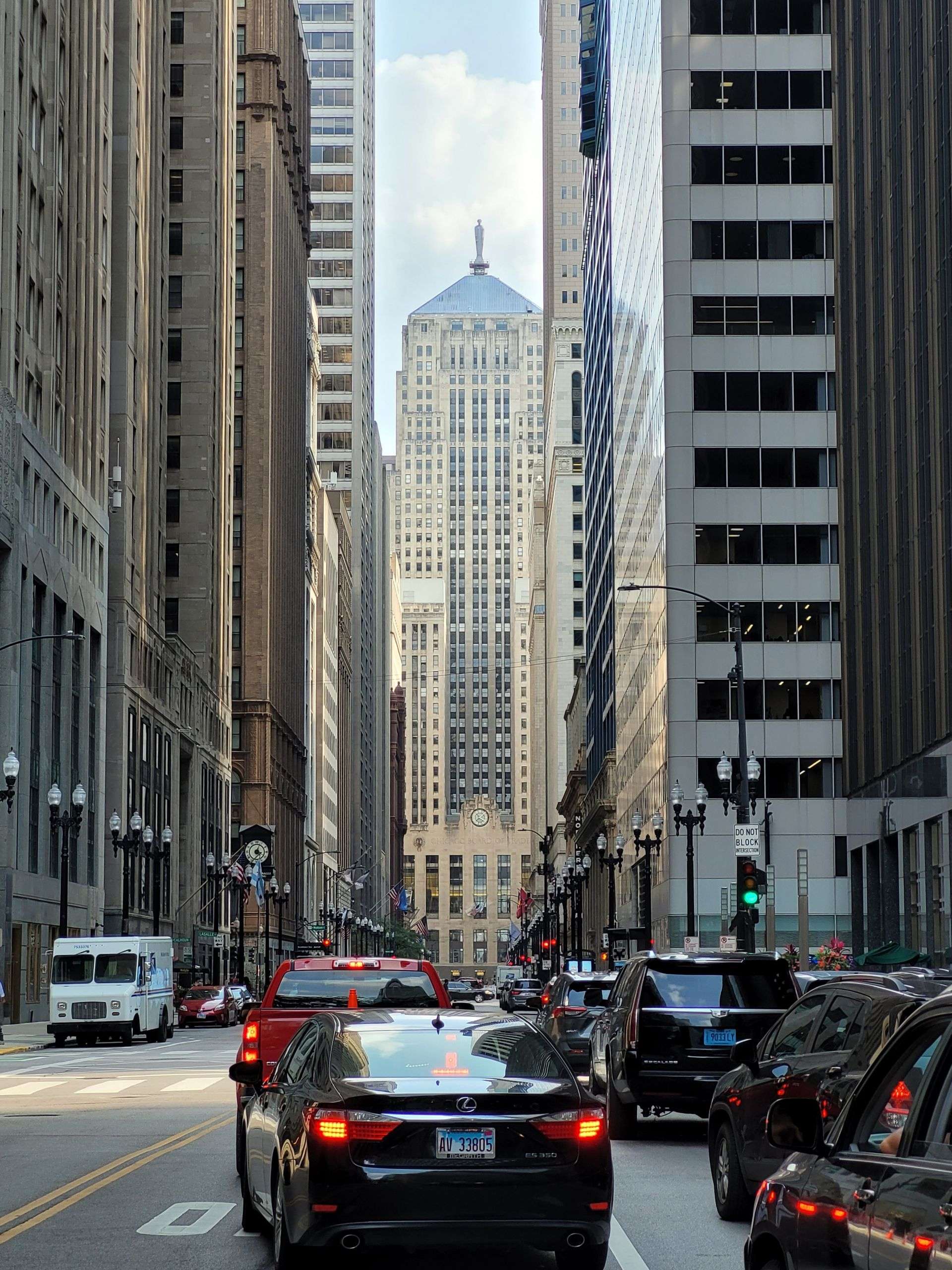 View of a busy Chicago street with cars and skyscrapers, featuring a landmark building.